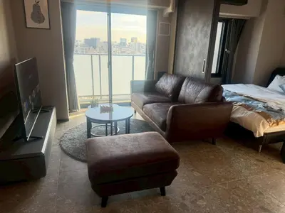 a living room with a couch and a bed at ROLES Ryusen 1001 in Tokyo