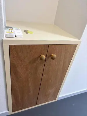 a wooden cabinet with two knobs on it at xinsuyuyuan in Tokyo