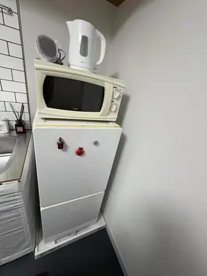 a microwave sitting on top of a dresser at xinsuyuyuan in Tokyo