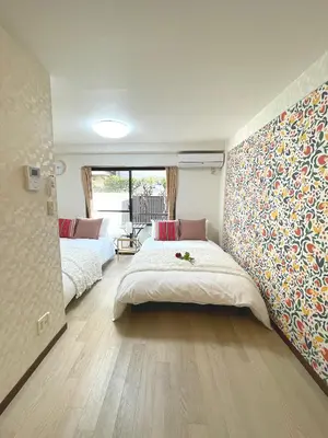 a bedroom with two beds and a wall mural at #3 \u65b0\u5bbf\u307e\u30672\u5206! \u6e05\u6f54\u3067\u5b89\u5168\u306a\u90e8\u5c4b! WiFi\u7121\u6599! in Tokyo