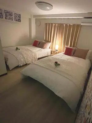 a bedroom with two beds with a flower on top of them at #3 \u65b0\u5bbf\u307e\u30672\u5206! \u6e05\u6f54\u3067\u5b89\u5168\u306a\u90e8\u5c4b! WiFi\u7121\u6599! in Tokyo