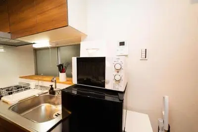 a microwave sitting on top of a kitchen counter at Shin-Nakano House in Tokyo