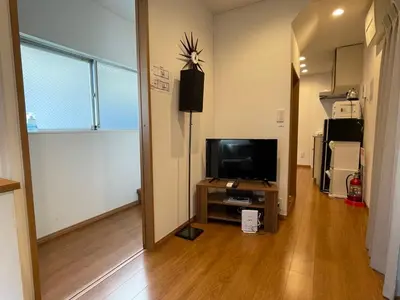 a living room with a flat screen tv and a television stand at Shin-Nakano House in Tokyo