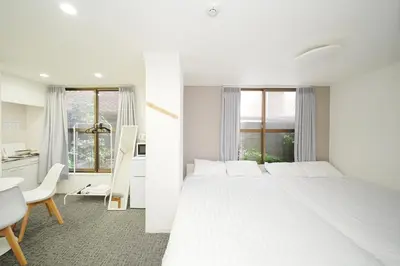 a white bedroom with a large bed and a desk at GLOU Koiwa Tokyo - Economic APT in a Japanese Local Shopping Street, with Direct Access to Shinjuku & Akihabara in Tokyo