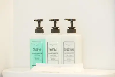 three bottles of shampoo and conditioner sitting on a counter at GLOU Koiwa Tokyo - Economic APT in a Japanese Local Shopping Street, with Direct Access to Shinjuku & Akihabara in Tokyo