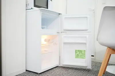a white refrigerator with its door open in a room at GLOU Koiwa Tokyo - Economic APT in a Japanese Local Shopping Street, with Direct Access to Shinjuku & Akihabara in Tokyo