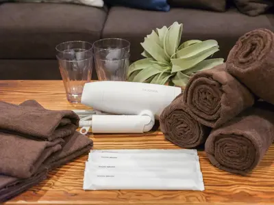 a table with towels towels and a charger on it at \u30d5\u30ea\u30fc\u30b8\u30a2\u6d45\u8349stay in Tokyo