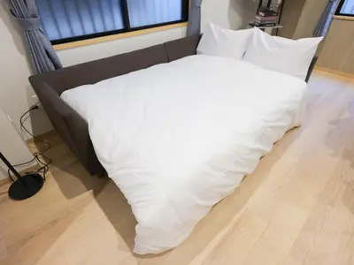 a bed with a white blanket on the floor at \u30d5\u30ea\u30fc\u30b8\u30a2\u6d45\u8349stay in Tokyo