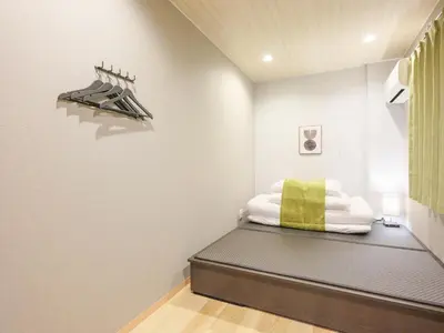 a bedroom with a bed with a green pillow on it at \u30d5\u30ea\u30fc\u30b8\u30a2\u6d45\u8349stay in Tokyo