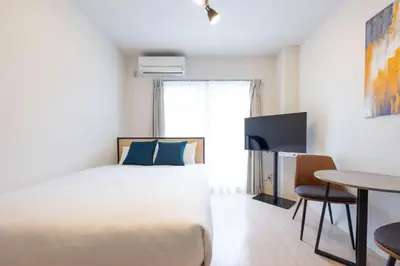 a bedroom with a bed and a desk and a table at \u30a6\u30a4\u30f3\u30d9\u30eb\u30bd\u30ed\u6771\u84b2\u7530 in Tokyo