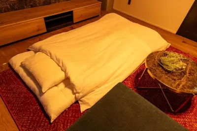 a bed sitting on top of a red rug with a table at ONLY YOU HOTEL - Vacation STAY 02976v in Tokyo