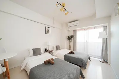 a bedroom with two beds with stuffed animals on them at \u65b0\u5bbf\u9ad8\u5c64\u30de\u30f3\u30b7\u30e7\u30f3 \u99c5\u304b\u30892\u5206 in Tokyo