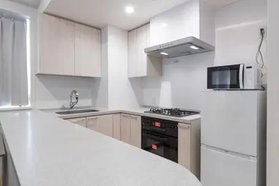a kitchen with white counters and a stove top oven at \u5e83\u5c3e\u30a4\u30fc\u30b9\u30c8 in Tokyo