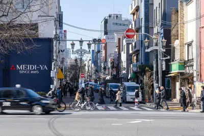 a busy city street with people crossing the street at \u5e83\u5c3e\u30a4\u30fc\u30b9\u30c8 in Tokyo