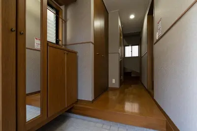 an empty hallway with wooden doors and a hallway at The \u30cd\u30b3\u30b6\u30cd HAUS in Urayasu