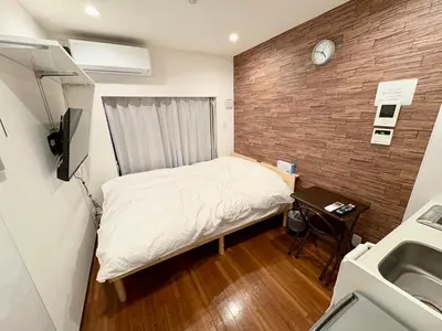 a small room with a bed and a sink at \u798f\u83ef\u30d3\u30eb205\u53f7\u5ba4 in Tokyo