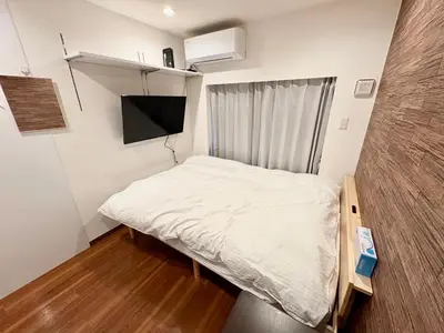 a small bedroom with a bed and a flat screen tv at \u798f\u83ef\u30d3\u30eb205\u53f7\u5ba4 in Tokyo