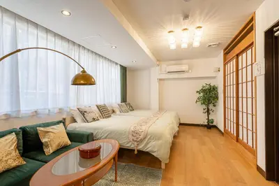 a bedroom with a bed and a couch and a table at Asakusa4\u5206\u949f\u6674\u7a7a\u585410\u5206\u949f\u65e5\u5f0f\u6e29\u99a8\u548c\u5bbf201 MAX9\u4eba \u9ad8\u901fWIF in Tokyo