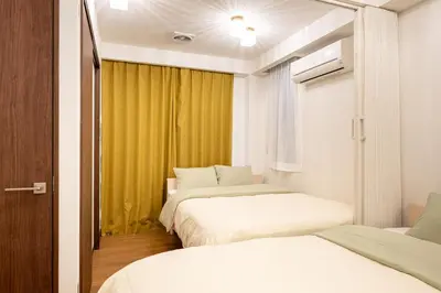 two beds in a room with yellow curtains at Asakusa4\u5206\u949f\u6674\u7a7a\u585410\u5206\u949f\u65e5\u5f0f\u6e29\u99a8\u548c\u5bbf301 MAX9\u4eba \u9ad8\u901fWIF in Tokyo