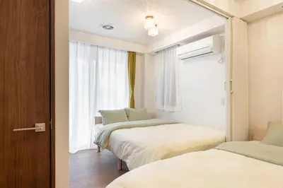 two beds in a room with a window at Asakusa4\u5206\u949f\u6674\u7a7a\u585410\u5206\u949f\u65e5\u5f0f\u6e29\u99a8\u548c\u5bbf301 MAX9\u4eba \u9ad8\u901fWIF in Tokyo