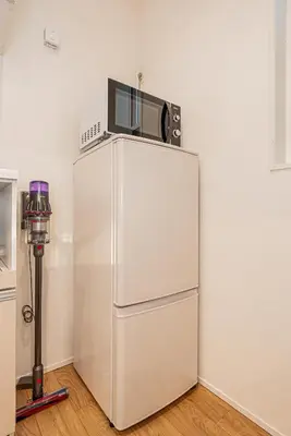 a microwave sitting on top of a refrigerator at Oasis Omori New House - 30min to Haneda - 2 Adjacent Homes in Tokyo