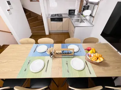 a table with white plates and a bowl of fruit on it at nestay villa tokyo akasaka in Tokyo