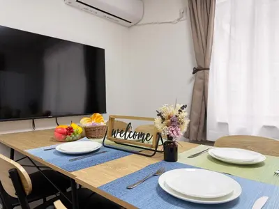 a dining room table with white plates and flowers on it at nestay villa tokyo akasaka in Tokyo