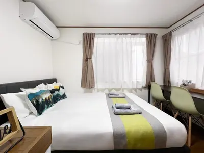 a bedroom with a bed and a desk and a window at nestay villa tokyo akasaka in Tokyo