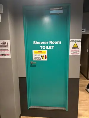 a green door in a room with a sign on it at Yoroi Asakusa Hotel in Tokyo
