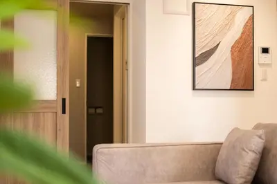 a living room with a couch and a picture on the wall at SUNRISE STAY Asakusa in Tokyo