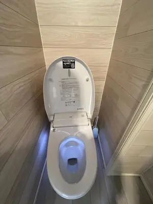 a white toilet in a bathroom with the lid up at kitashijyuku in Tokyo