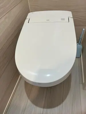 a white toilet in a room with a wooden floor at kitashijyuku in Tokyo