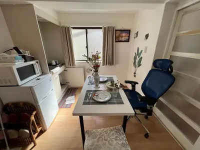 a small kitchen with a table and a microwave at kitashijyuku in Tokyo