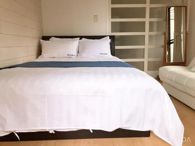 a bed with white sheets and pillows in a bedroom at kitashijyuku in Tokyo