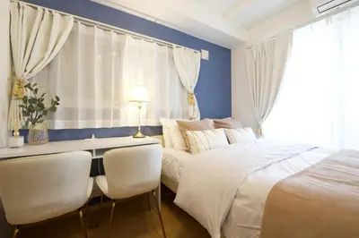 a bedroom with a bed and a desk and chairs at Emilio301 in Tokyo