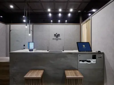 a lobby with a counter with a laptop and two benches at GRAND MONday GINZA in Tokyo
