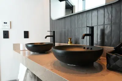 a bathroom with two black sinks on a counter at GRAND MONday GINZA in Tokyo