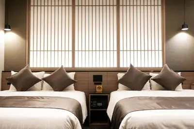 two beds in a room with large windows at GRAND MONday GINZA in Tokyo