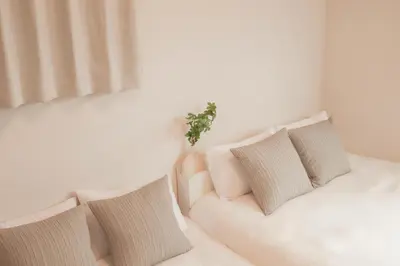a white bed with pillows and a plant on it at \u65e5\u548c komagome in Tokyo