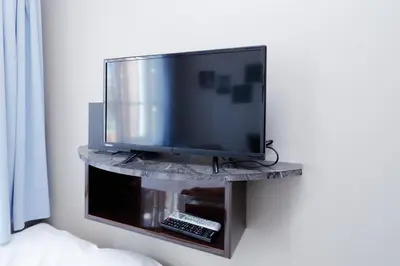 a flat screen tv sitting on a stand on a wall at Ra Grande by Tranova in Tokyo