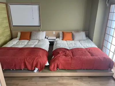 two beds sitting next to each other in a bedroom at \u6d45\u8349\u8907\u5f0f\u30a2\u30d1\u30fc\u30c8\u30e1\u30f3\u30c8\u6c11\u5bbf \u6700\u592710\u4eba in Tokyo