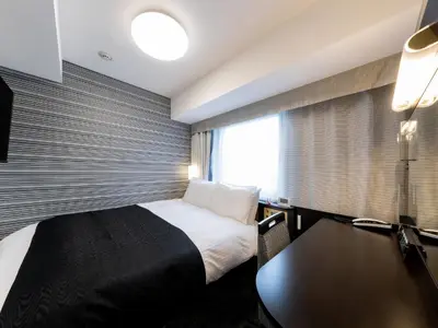 a hotel room with a bed and a window at APA Hotel Omori Ekimae Higashi in Tokyo