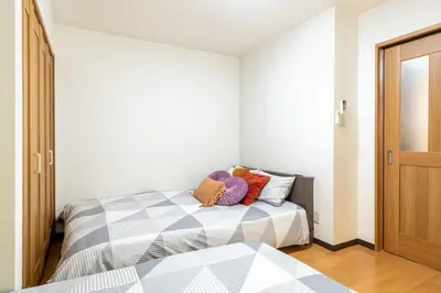 a bedroom with a bed with two pillows on it at \u4e2d\u91ce\u65b0\u6a4b\u99c5\u5f92\u6b692\u5206 \u65b0\u5bbf\u99c5 in Tokyo