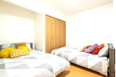two beds in a room with white walls at \u4e2d\u91ce\u65b0\u6a4b\u99c5\u5f92\u6b692\u5206 \u65b0\u5bbf\u99c5 in Tokyo