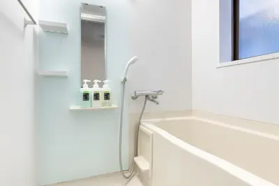 a white bathroom with a tub and a sink at \u4e2d\u91ce\u65b0\u6a4b\u99c5\u5f92\u6b692\u5206 \u65b0\u5bbf\u99c5 in Tokyo