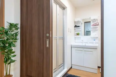 a bathroom with a sink and a wooden door at \u4e2d\u91ce\u65b0\u6a4b\u99c5\u5f92\u6b692\u5206 \u65b0\u5bbf\u99c5 in Tokyo
