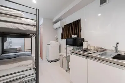 a small kitchen with a sink and a bunk bed at SAIEI Hotel in Tokyo