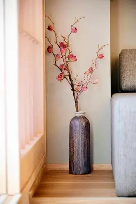 a blue vase with pink flowers in a room at MKG HOTEL Asakusa in Tokyo