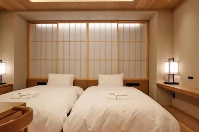 two beds with glasses on them in a room at MKG HOTEL Asakusa in Tokyo