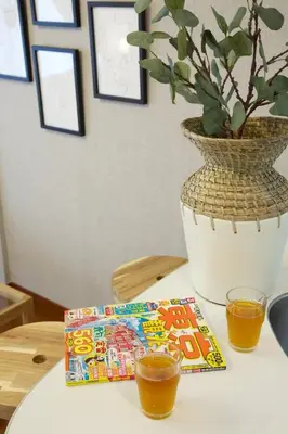 a table with a book and a vase with a plant at BAi\u6b4c\u821e\u4f0e\u753a2\u4e01\u76ee in Tokyo